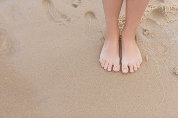 Fototapeta na wymiar cropped view of child standing on sandy beach alone