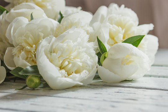 Fototapeta Bouquet of white peonies on the old white wooden boards