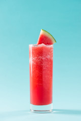 Glass of healthy watermelon juice in summertime on blue background.