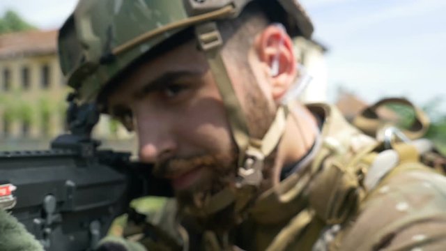 Closeup portrait of young army ranger aiming gun during a military training