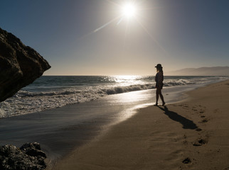 Woman walks along beach shoreline