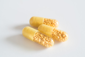 Open yellow capsule with vitamins or biological additives, Dietary supplement
