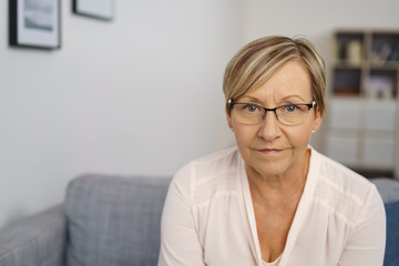 moderne frau mit brille in ihrem wohnzimmer