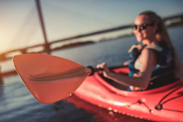 Woman kayaking on sunset