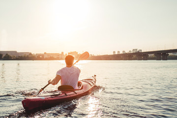 Man kayaking on sunset