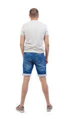 Obraz premium Back view of young man in shorts looking. Rear view people collection. backside view of person. Isolated over white background.