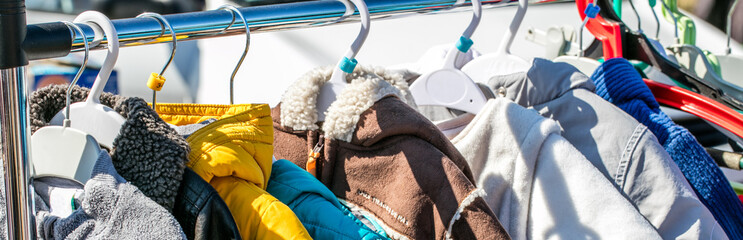 used baby winter clothes, jackets and coats displayed on rack