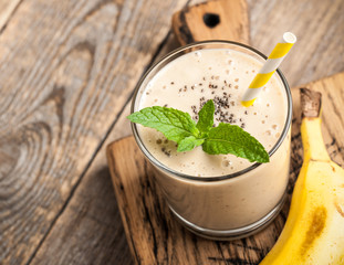 Banana smoothie glass on wooden table