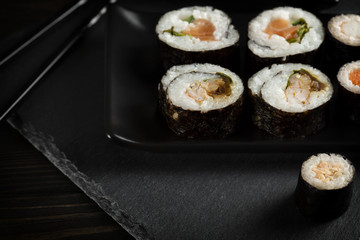 Sushi rolls on black plate