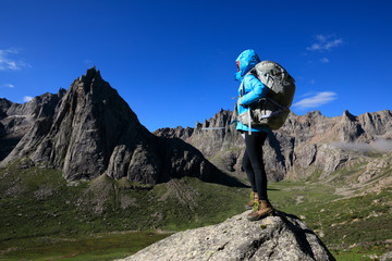 woman with backpack hiking in mountains travel lifestyle success concept adventure active vacations...