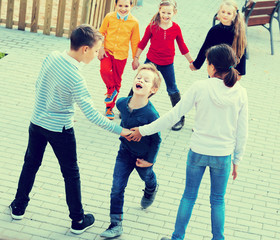 Group of smiling glad children playing red rover