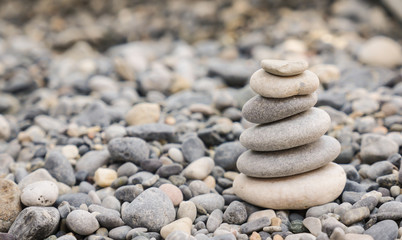 Fototapeta na wymiar Small tower made of pebbles on a rocky beach