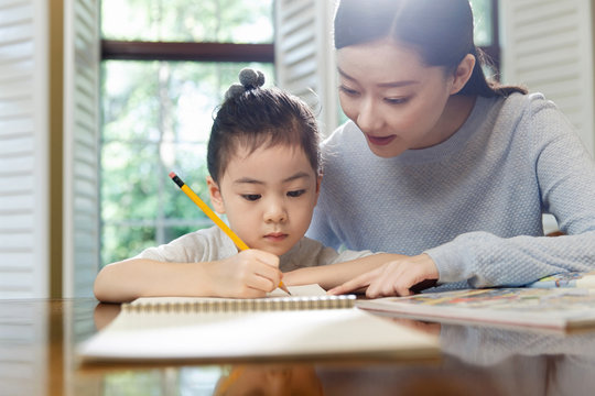 Mother helping with daughter's homework