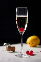 Cocktail with champagne lemon and cherry.