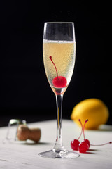 Cocktail with champagne lemon and cherry.