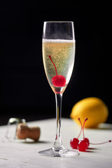 Cocktail with champagne lemon and cherry.