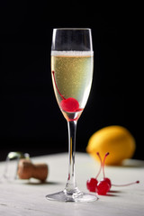 Cocktail with champagne lemon and cherry.