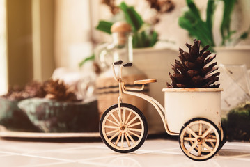 Soft Focus Picture of Still Life Vintage Metal Bicycle Vase with Pine Cone Decorate on Table