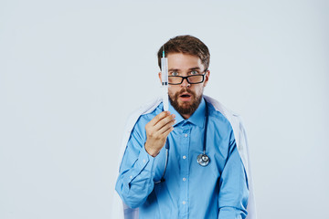 Man with a beard on a light background holds a syringe, doctor, medicine