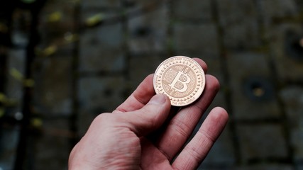 Gold bitcoin coin in hand