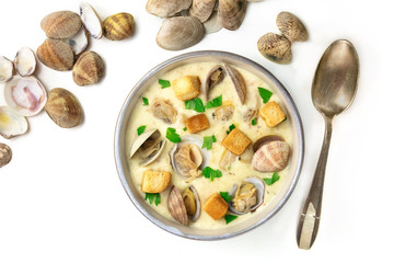 Bowl of clam chowder soup with shells on white background