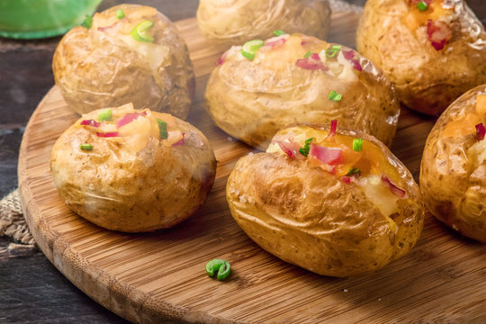 Closeup of steaming baked potatoes with cheese and bacon