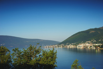 Fototapeta premium View of Boko Kotorska bay in Montenegro on a hot summer day. Vacation on the beach, the morning landscape in the bay.