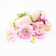 Paper gift box and pink flower on white background. Flat lay, top view.