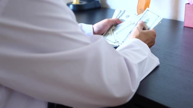 Corruption, bribery and fraud are. a close-up of a doctor taking money. 4k . slow motion