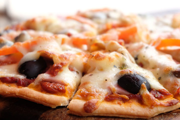 Close up pizza with ham cheese tomatoes and olives.