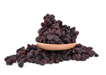 Dried Grapes into a spoon isolated in white background