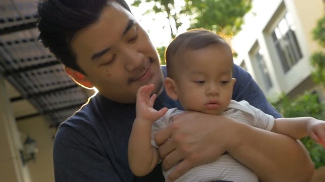 Slow motion of Happy little Asian boy playing with his father outdoor