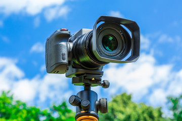 Digital camera closeup on a background of sky and clouds. Shooting on location and nature.