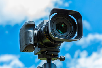 Digital camera closeup on a background of sky and clouds. Shooting on location and nature.