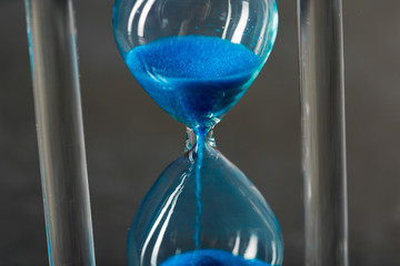 Time is passing. Blue hourglass close up