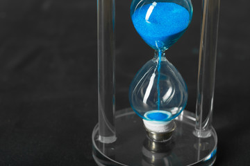 Time is passing. Blue hourglass close up