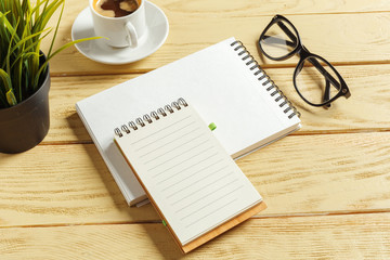 top view. coffee cup with coffee. pen putting on blank notebook.