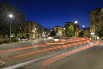 Fototapeta na wymiar Car light trails on the crossroad during night in the city of Umbertide, Italy