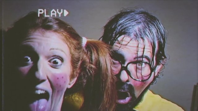 Fake VHS tape: a weird presenter and his female assistant doing a peek-a-boo (surprising the viewer). Funny bizarre foolish characters.
