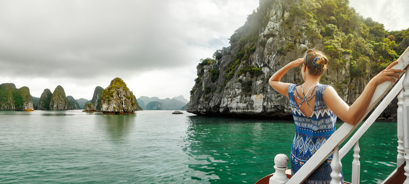 Pretty woman in a dress is traveling by boat in Halong Bay. Vietnam.