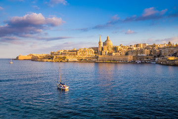 Valletta, Malta - Sail boat at the walls of Valletta with St.Paul's Cathedral and beautiful blue sky