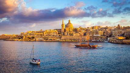 Valletta, Malta - Sail boats at the walls of Valletta with Saint Paul's Cathedral and beautiful sky and clouds in the morning - obrazy, fototapety, plakaty