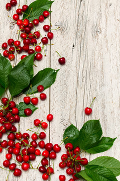 Wooden background with ripe cherries
