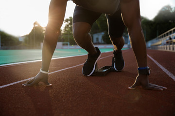 Cropped image of a young african male sprinter getting ready