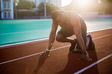 Young muscular concentrated athlete at the start