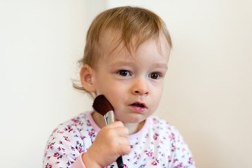 2 years old girl child is doing makeup