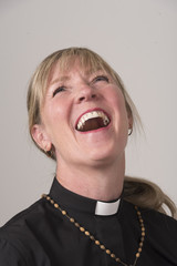 Portrai of a woman priest with blond hair and laughing