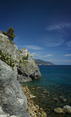 Naklejka premium Felswand an die Ligurische Küste mit Blaue Himmel und grünes Wasser