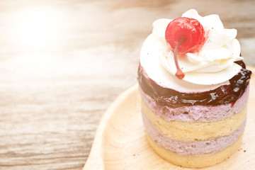 Cupcake with whipped cream and cherry from top view