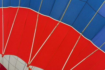 Fototapeta premium Graphic and geometric texture of hot air balloon, Bottom view, as background for bright moments of life, vivid red and blue colors